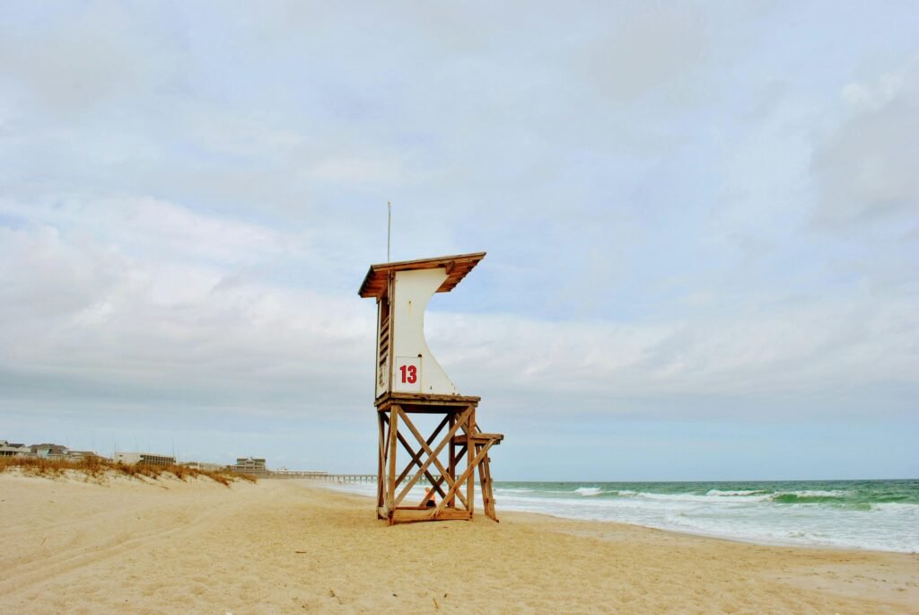 Peaceful beach scene in NC featuring a lifeguard tower and ocean waves.