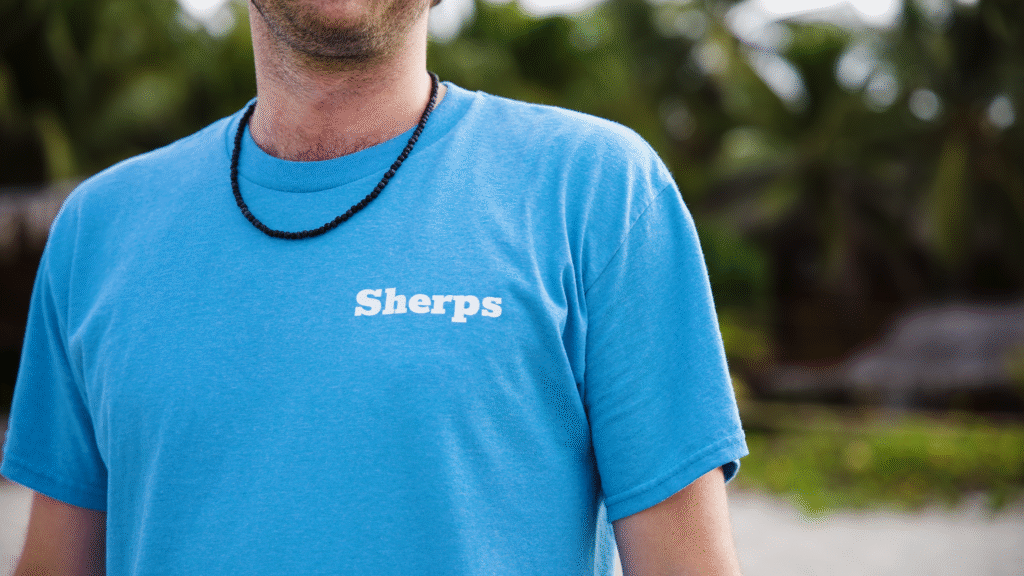 Mack Linstead, Beach Sherpa Founder, in a light blue t-shirt with the word Sherps in white on the left side of his chest.